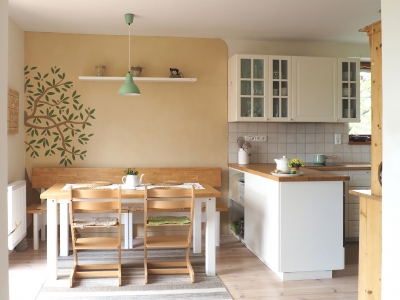 Pohled na jídelnu/kuchyň – za jídelním stolem se nachází (stejně jako naproti za pohovkou) sgrafito olivovníku škrábané do hliněné omítky.