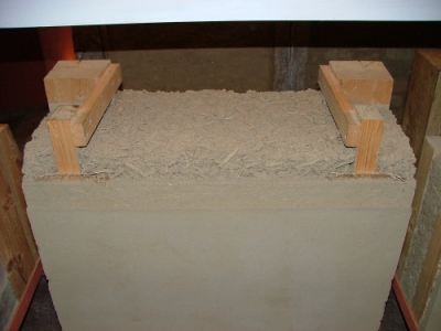 Stěna zateplená dřevěnou štěpkou, která je smíchána s vhkou hlínou a nadusána mezi dřevěné sloupky. Skladba z vnitřní strany (hliněná omítka je nanesena přímo na dusanou štěpku)