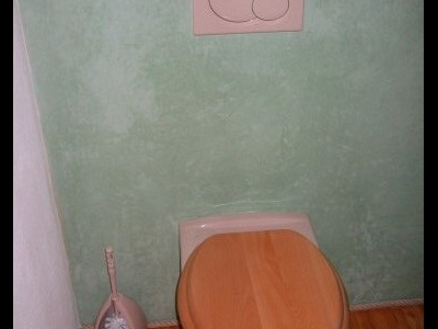 Stěna za toaletou je natažena vápennou stěrkou Tadelakt
