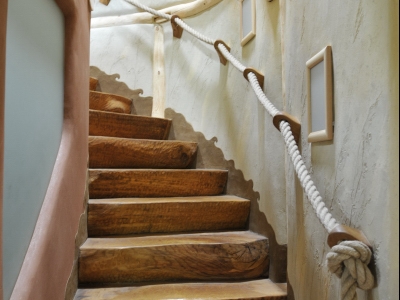 Stupně schodiště jsou vytvořeny z rozřezaného kmenu dubu.