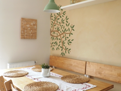 Pohled na jídelní stůl a lavice vytvořené na míru, sgrafito olivovníku má oproti olivovníku v obývacím pokoji živější, zelenou podobu.