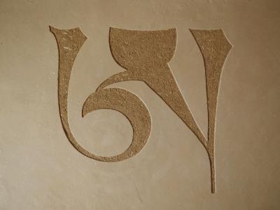 Vyškrábaný symbol v hliněné omítce Cottage.
