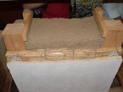 Stěna zateplená dřevěnou štěpkou, která je smíchána s vhkou hlínou a nadusána mezi dřevěné sloupky. Skladba z venkovní strany (vápenná omítka nanesená na rákosové desce)
