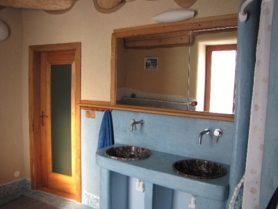 V interiéru koupelny převládají hliněné a tadelaktové povrchy nad obklady